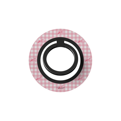 Pink gingham-patterned ring holder for phone with a black center on a white background