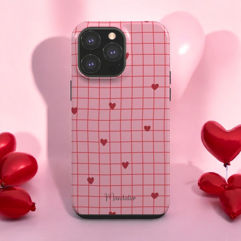 Heartfelt Grid Tough Phone Case placed on a desk with matching tech accessories, highlighting its durability and style.